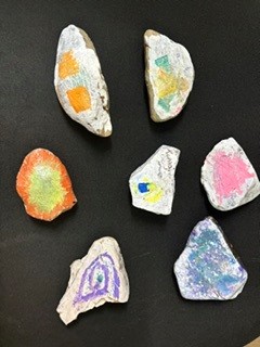 Six rocks decorated with colourful patterns by children