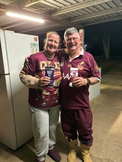 Two campers in maroon jerseys holding prizes in the camp kitchen