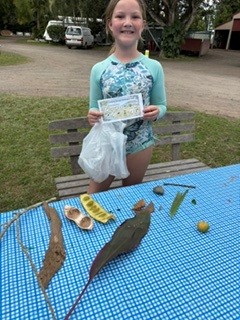 A young camper with leaves collected on a nature hunt
