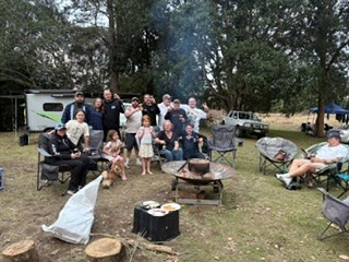 A group relaxing around a raised fire pit at camp